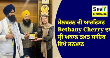 A woman presents a plaque to Bethany Cherry, surrounded by three men in traditional Sikh attire at Sea7 Australia.