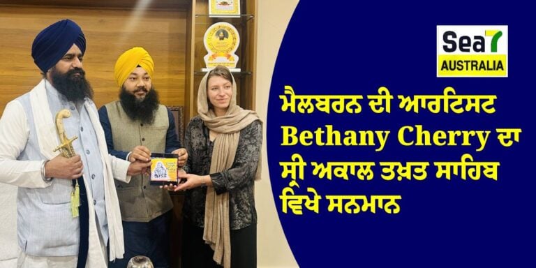 A woman presents a plaque to Bethany Cherry, surrounded by three men in traditional Sikh attire at Sea7 Australia.