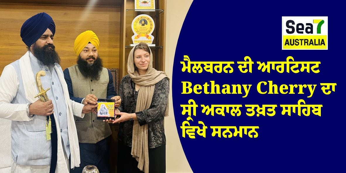 A woman presents a plaque to Bethany Cherry, surrounded by three men in traditional Sikh attire at Sea7 Australia.